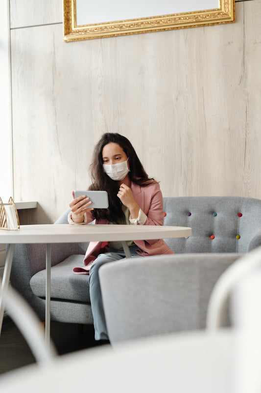 woman sitting on a sofa wearing a face mask