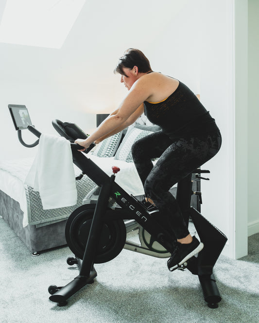 woman riding an Energym RE:GEN bike in gray room