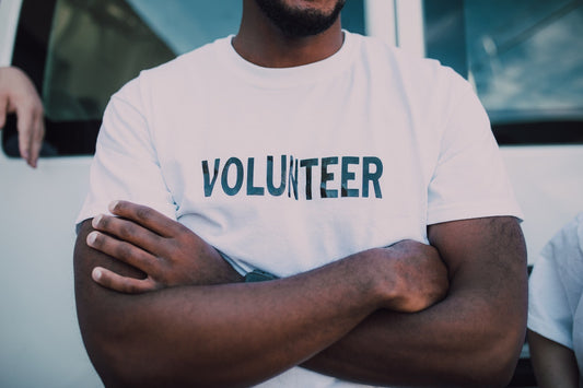 Man wearing a white t-shirt saying volunteer